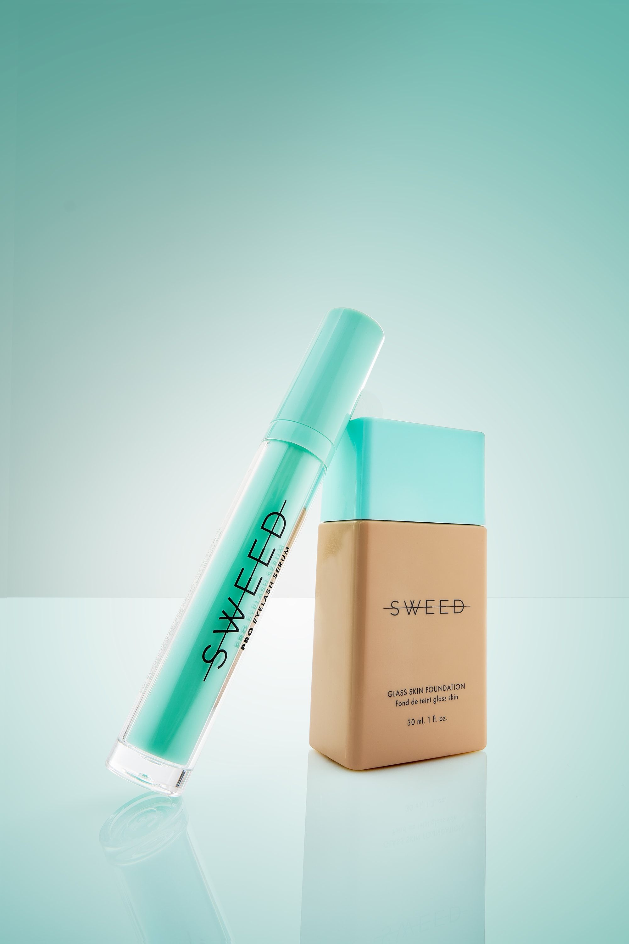 Serum do rzęs Sweed oparte o butelkę podkładu Glass Skin na miętowym tle