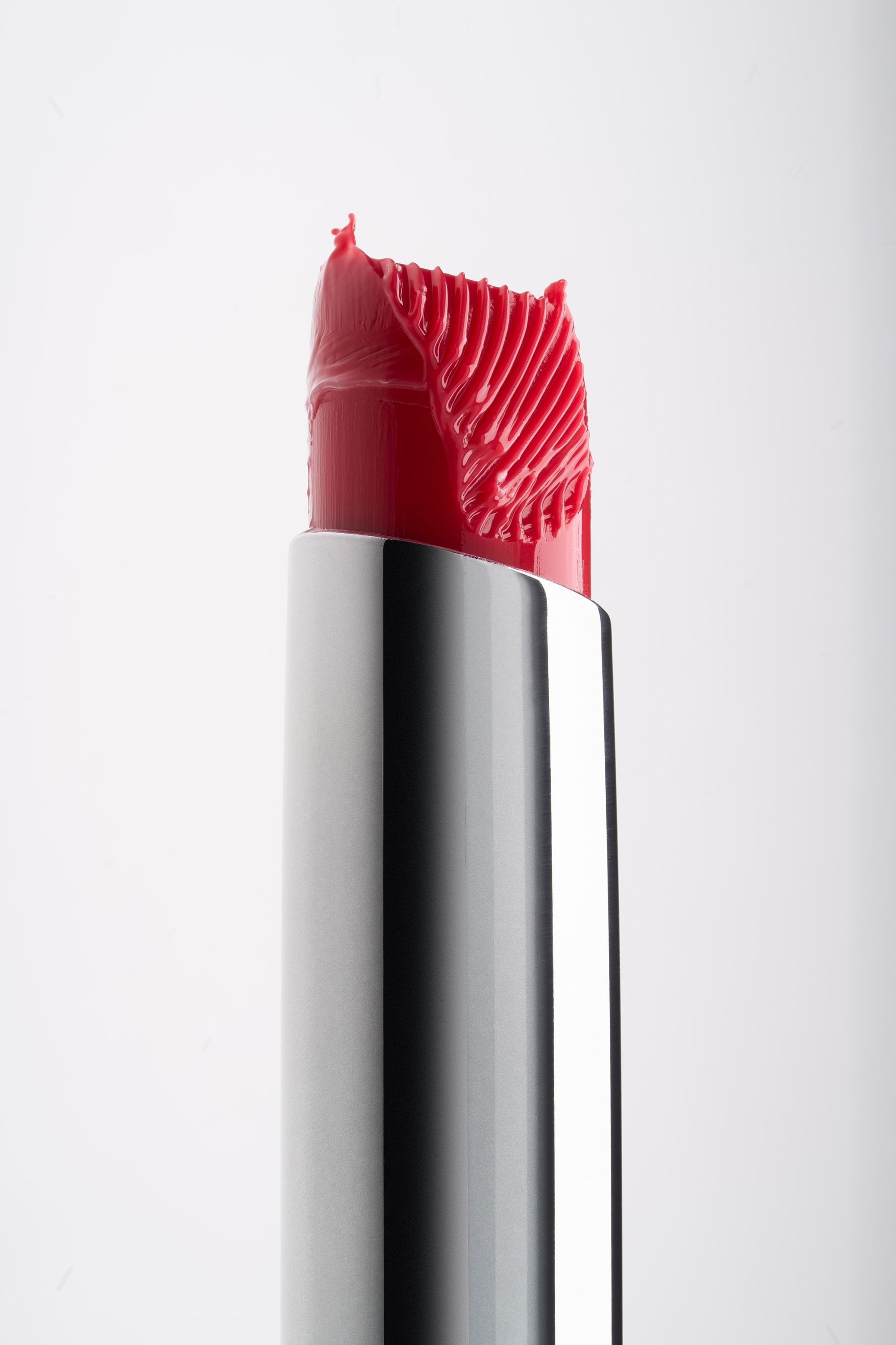 Pomadka Buttery Lip Balm w odcieniu scarlet z rzeźbioną końcówką na białym tle