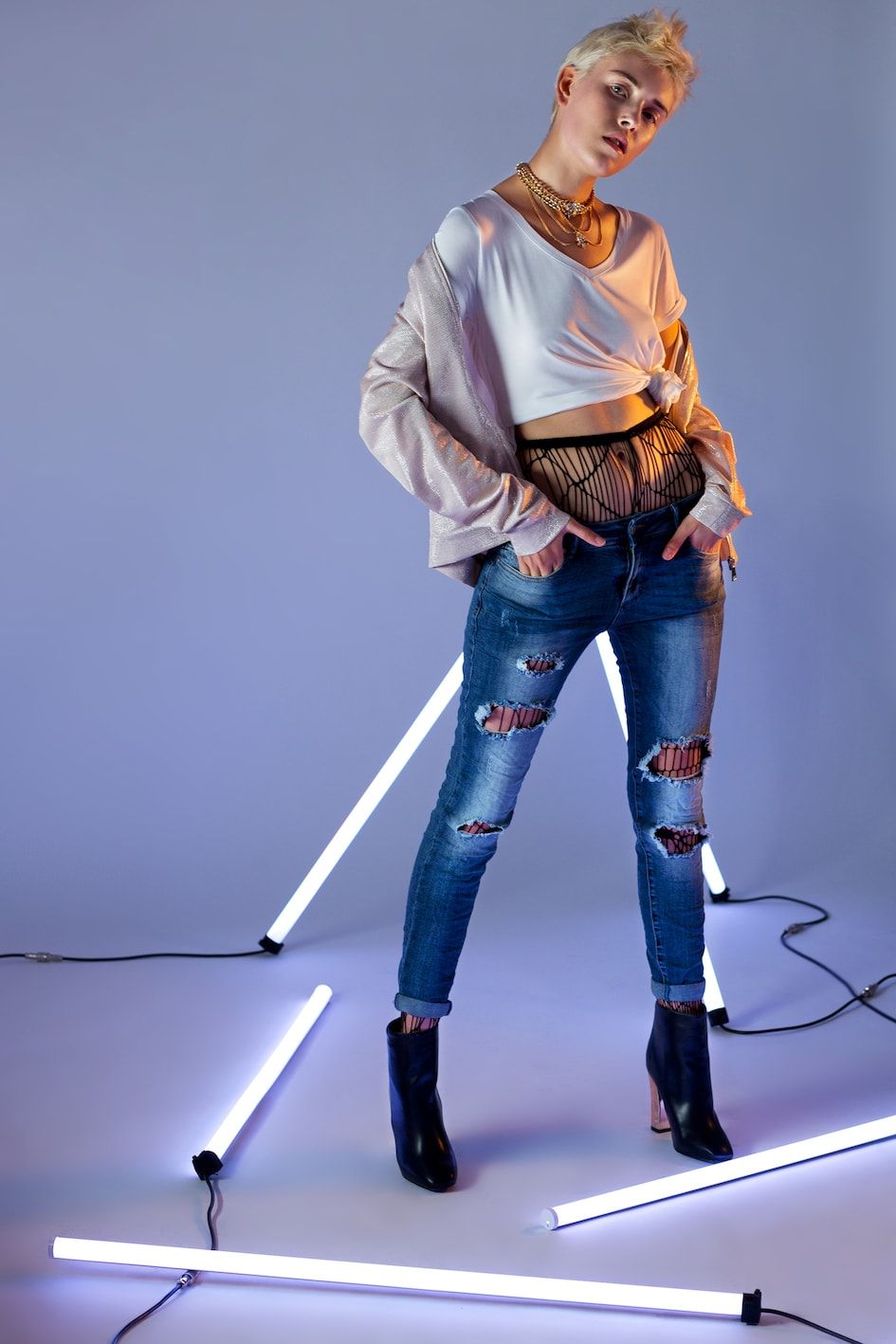 Modelka w podartych jeansach wśród świetlówek