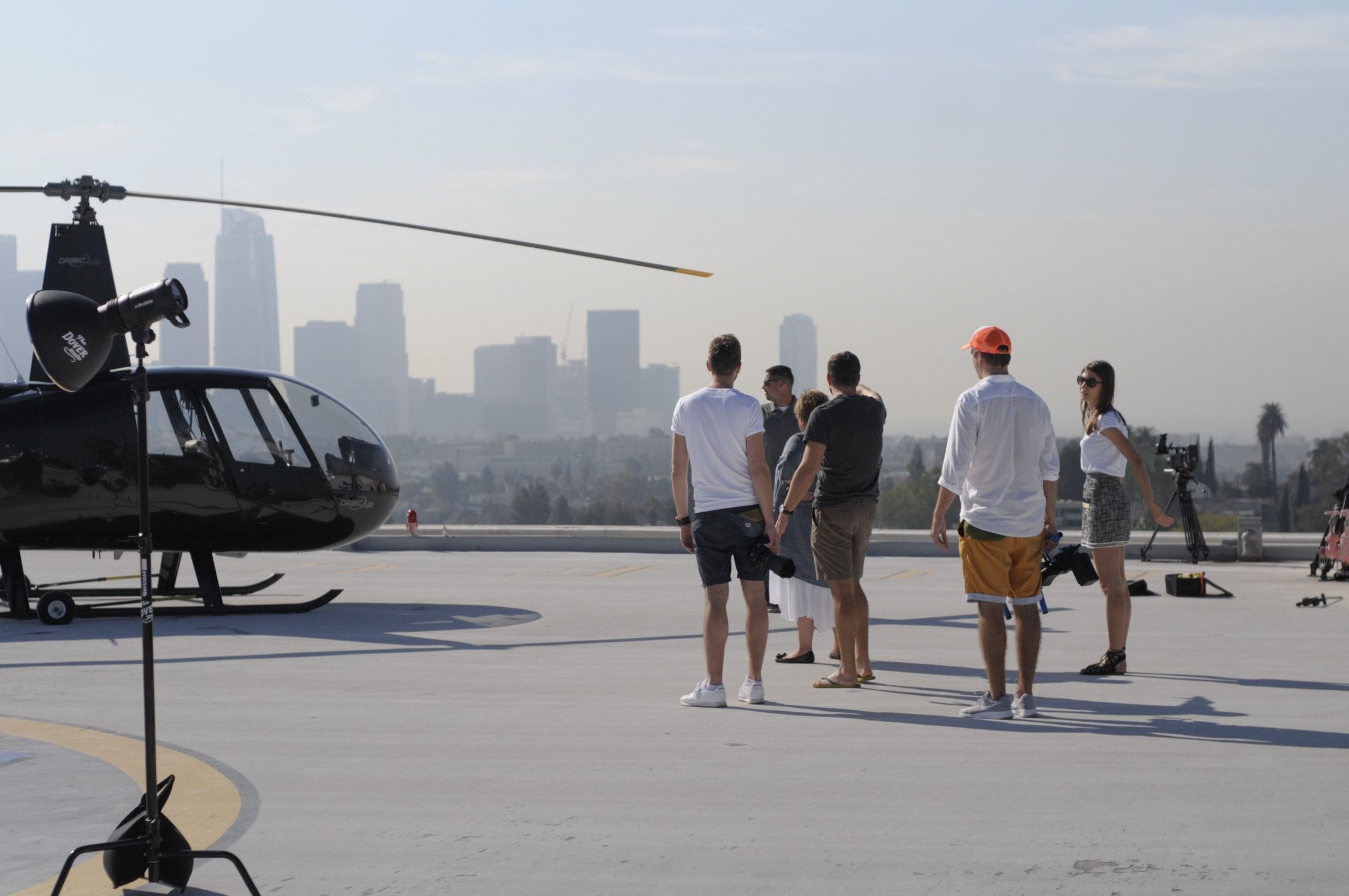 Ekipa sesji przy helikopterze na lądowisku nad panoramą Los Angeles